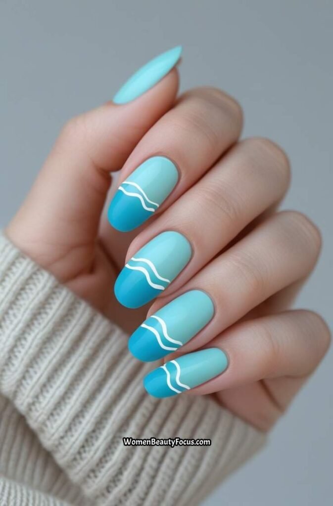 1. Soft Aqua Blue Nails with White Waves