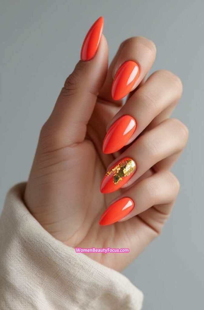 1. Vibrant Coral Almond Nails with Gold Accents