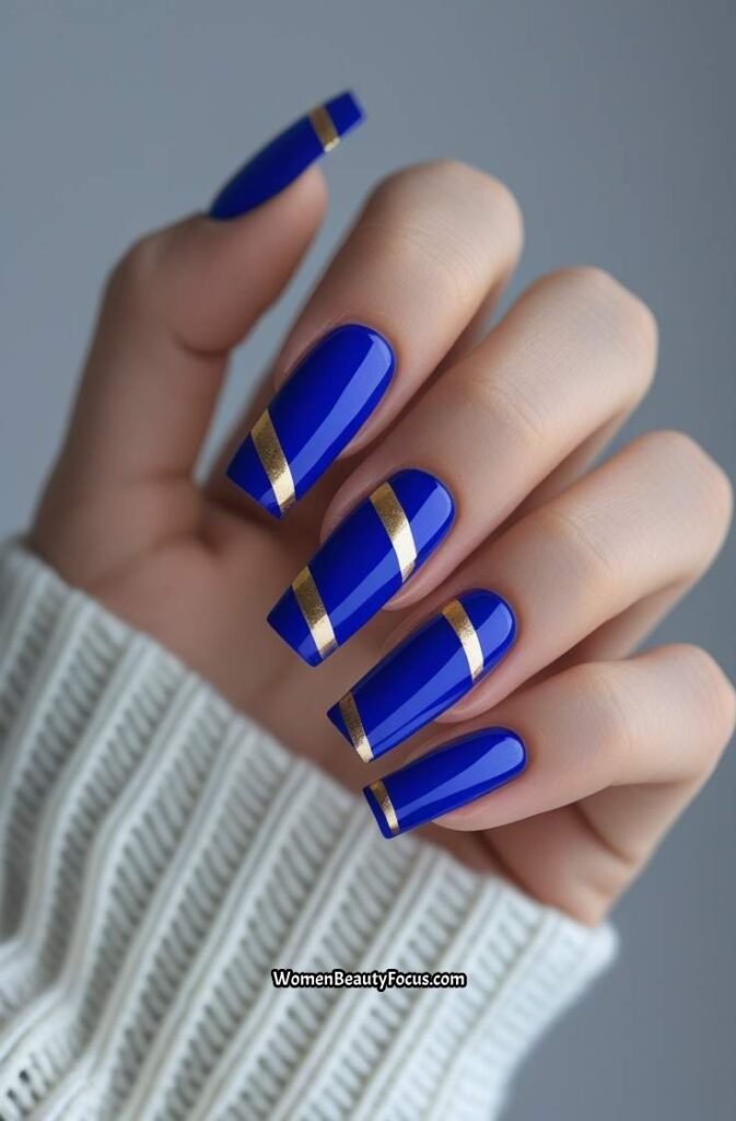 11. Royal Blue Nails with Gold Stripes