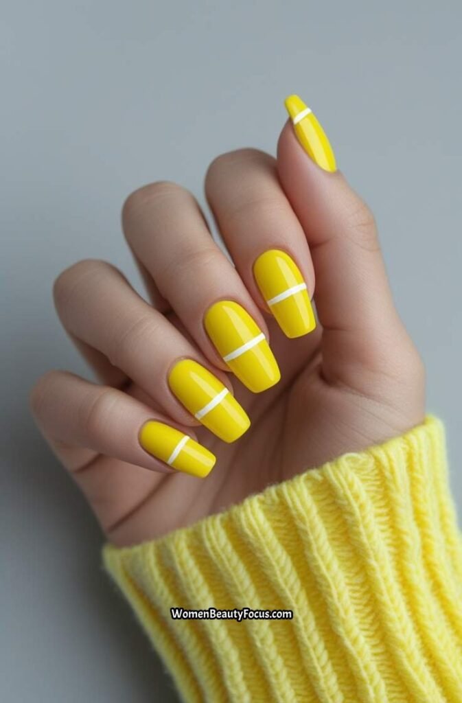 12. Bright Yellow Nails with White Dashes