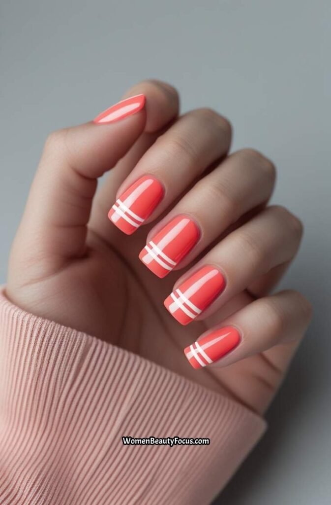 12. Coral Pink Nails with White Stripes