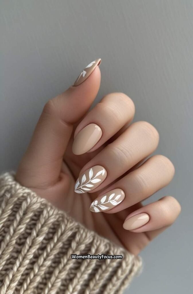 13. Soft Beige Oval Nails with White Leaf Art