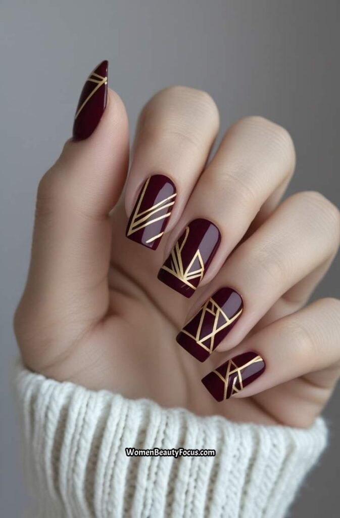 15. Burgundy and Gold Geometric Nail Art