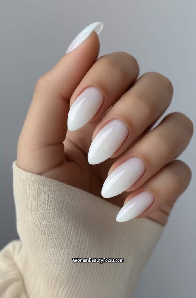 17. Milky White Almond Nails with Shimmer Overlay