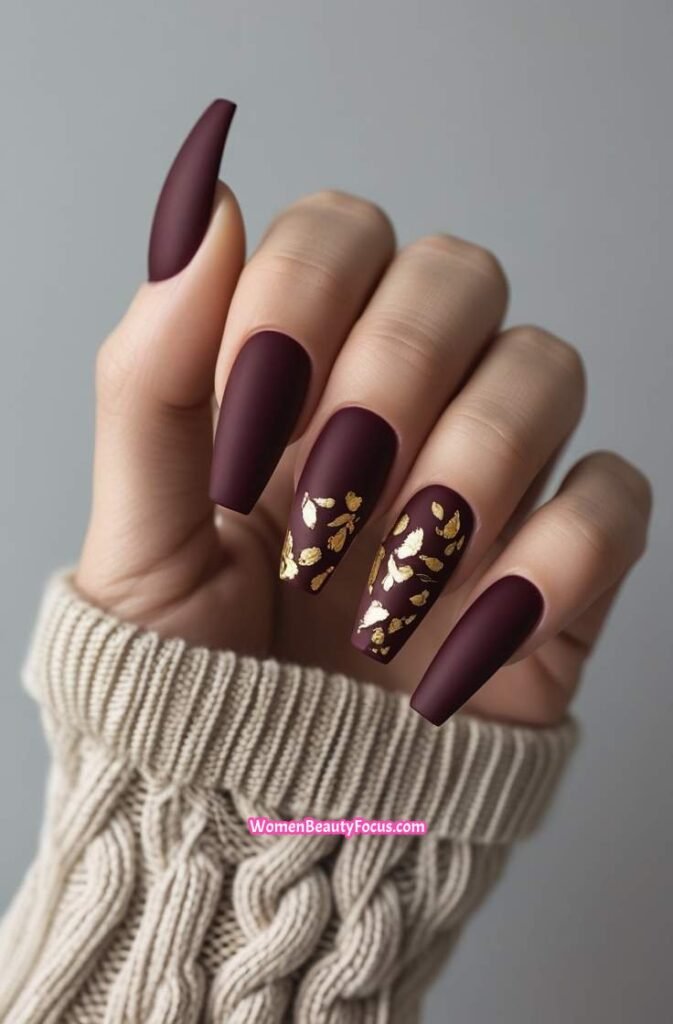 3. Matte Cherry Nails with Gold Leaf Accents