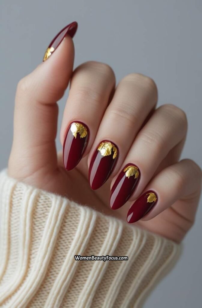 7. Cherry Red Nails with Gold Leaf Accents