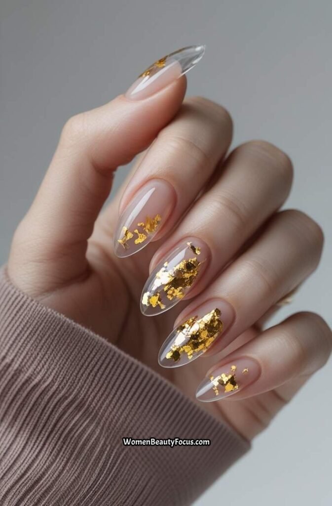 8. Clear Almond Nails with Gold Flakes